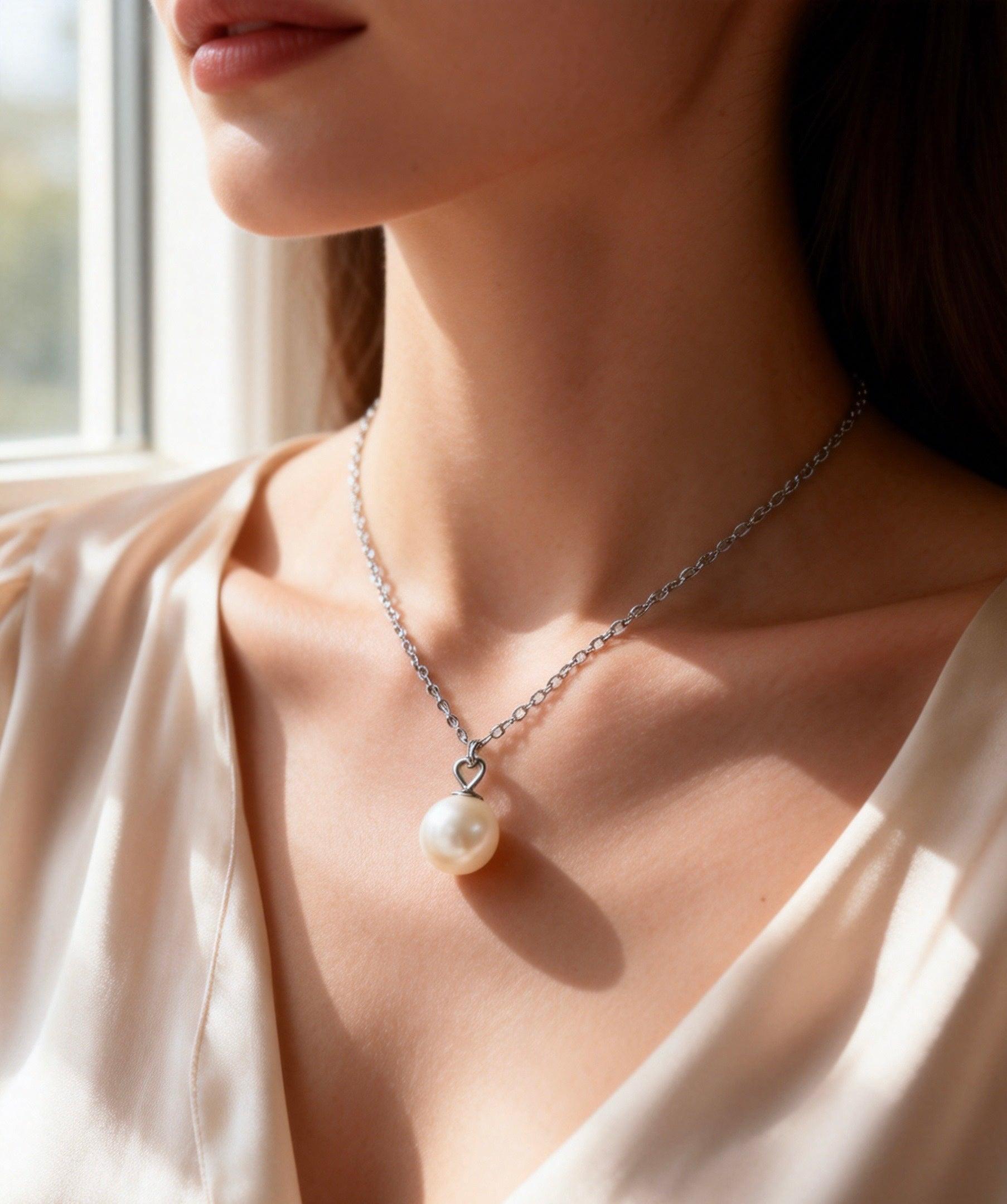 7mm round white Hepu saltwater pearl pendant on a delicate silver chain worn around a woman's neck.