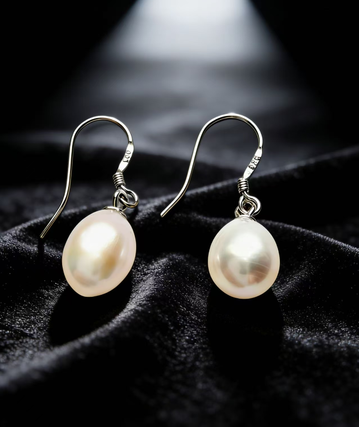 Baroque freshwater pearl drop earrings on 925 sterling silver hooks, featuring 7-8mm natural white pearls on black velvet.