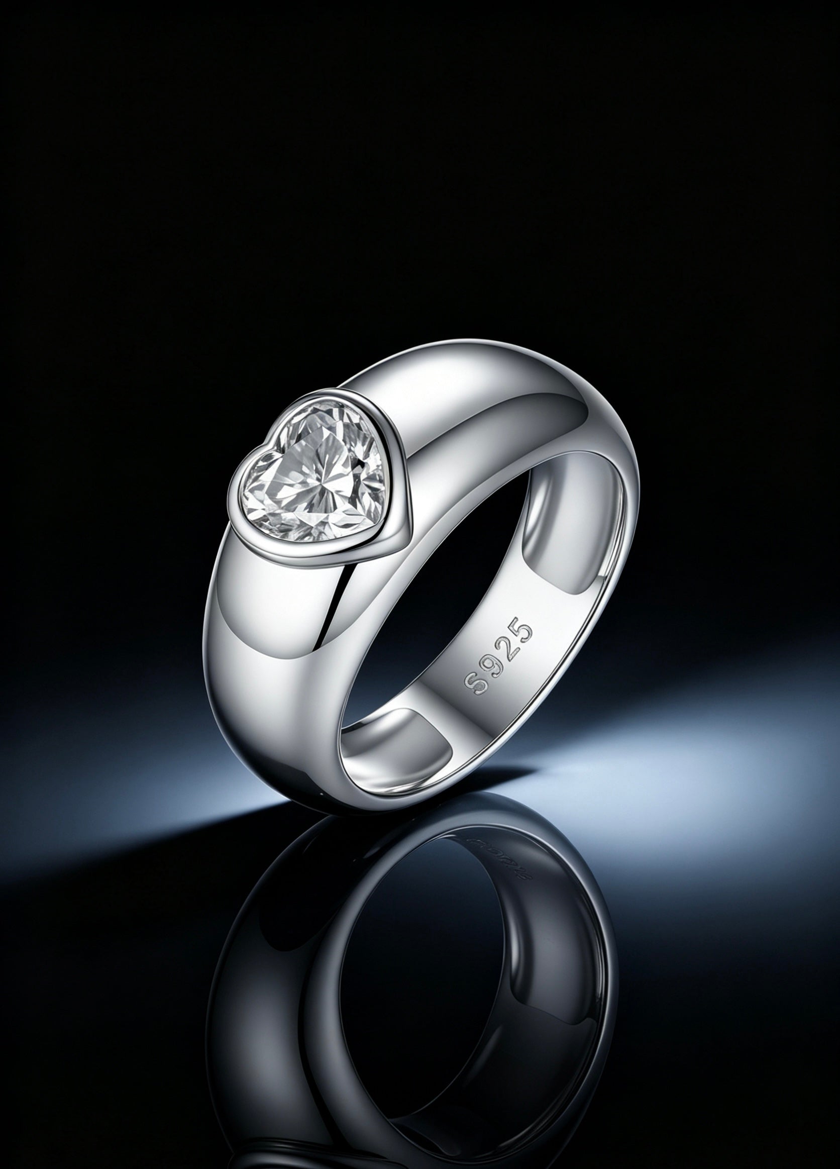 1.2ct heart-cut moissanite ring in a polished S925 silver dome band with a modern bezel setting on a reflective surface.
