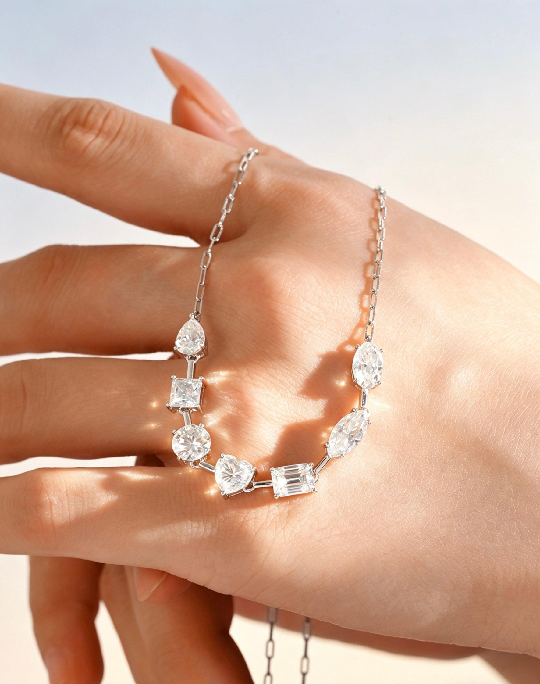 Sterling silver necklace featuring multi-shape D-color moissanite stones in a delicate link chain design.