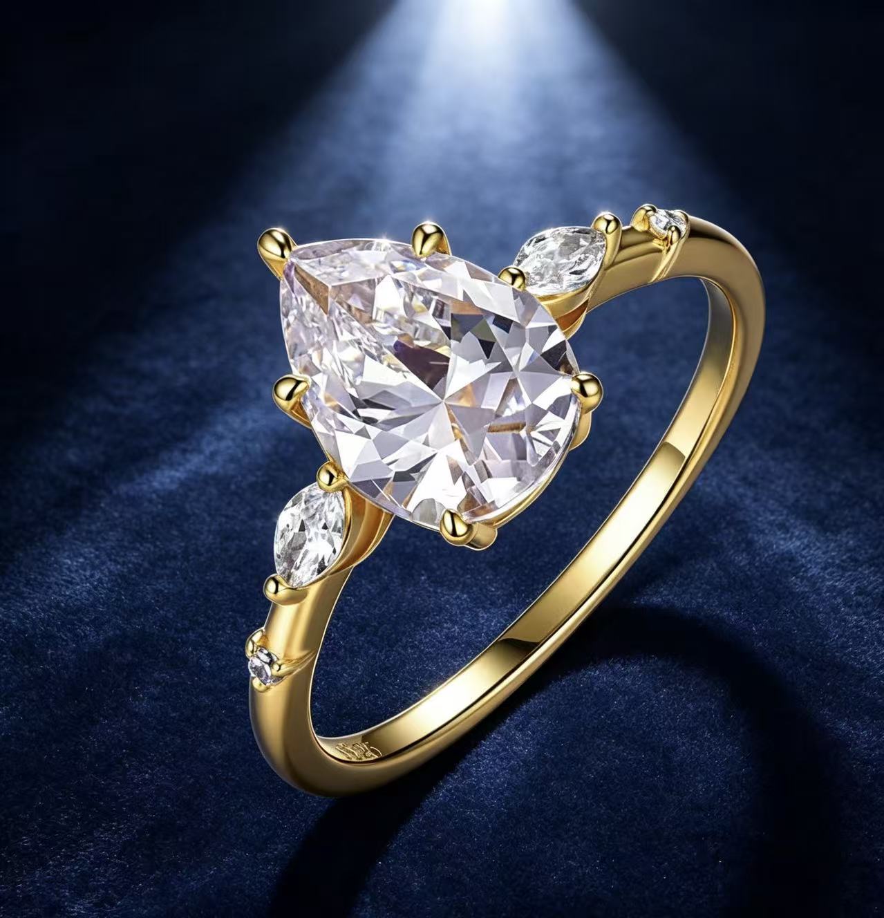 Gold pear-cut moissanite engagement ring with scattered marquise and round accent stones on a dark blue background.
