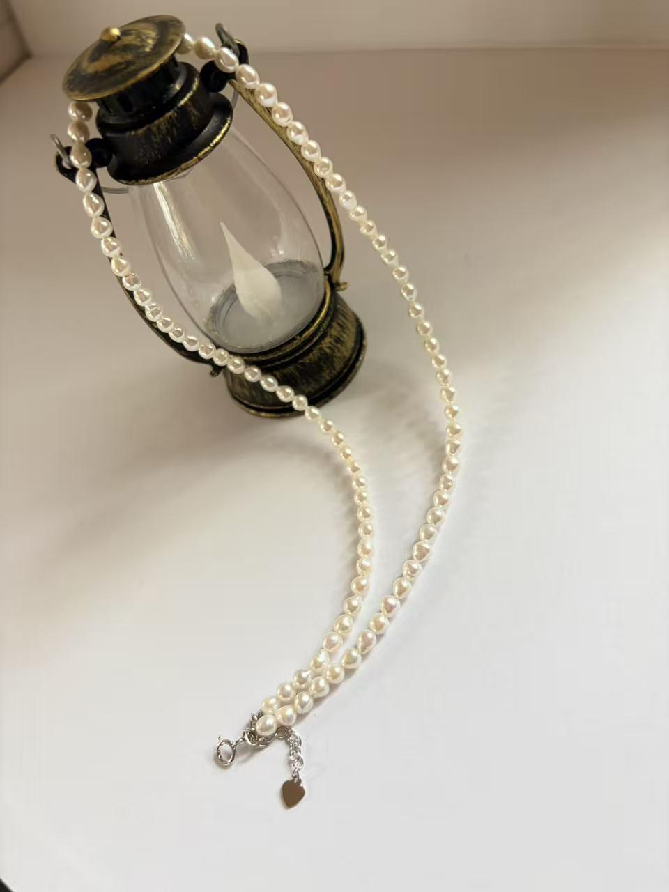 Minimalist 3–4mm baroque freshwater pearl seed necklace with 925 sterling silver clasp and heart charm.