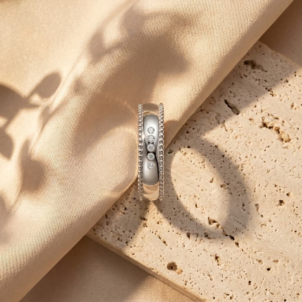 Wide sterling silver men's wedding band with a beaded edge and five sparkling D-color moissanite stones.