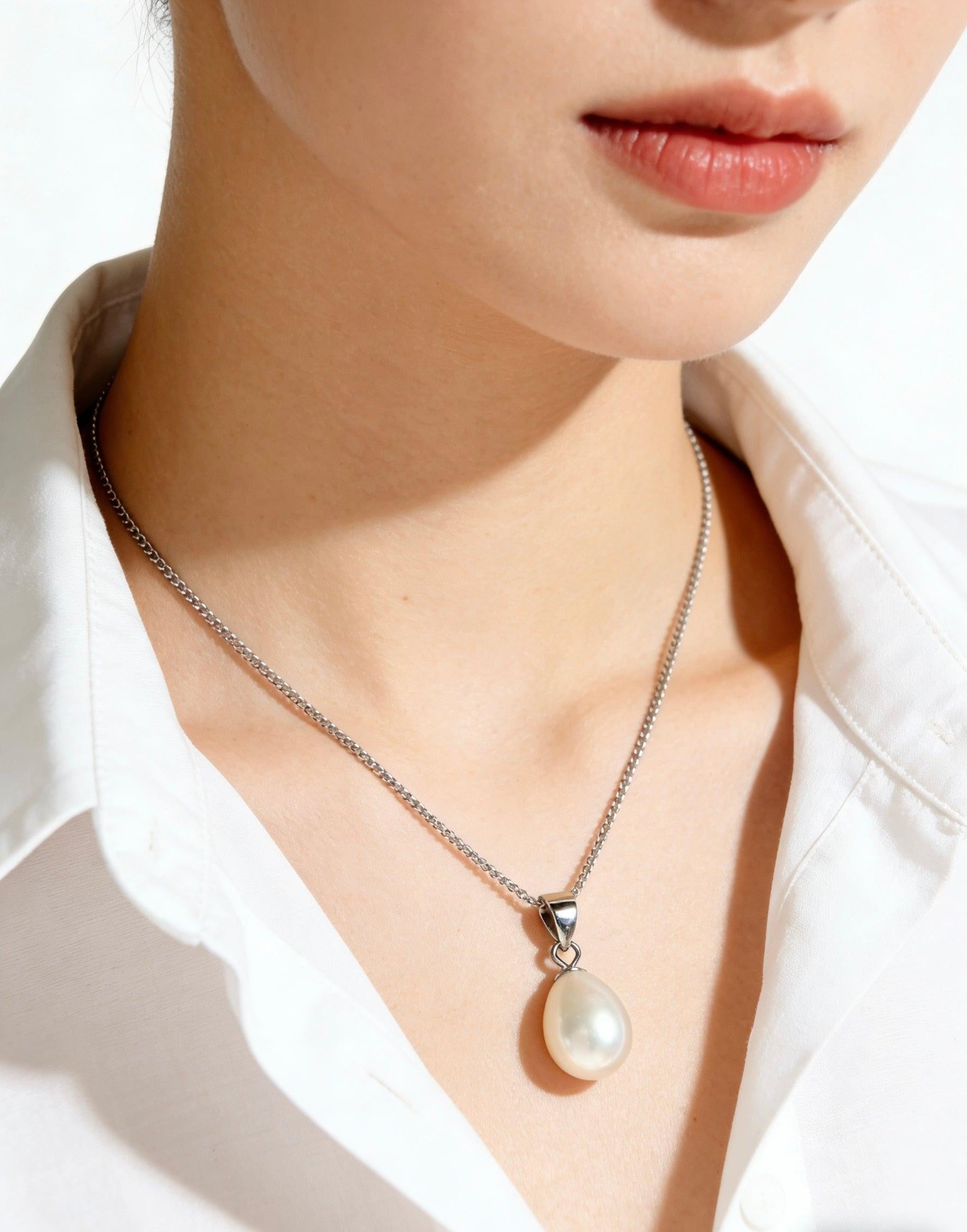 Baroque freshwater pearl pendant on a delicate 925 sterling silver chain worn against a white collared shirt.