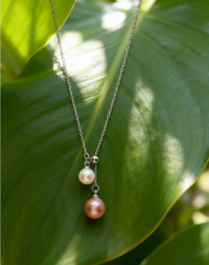 Double pearl pendant necklace with 6-7mm peach pink and 4-5mm white freshwater pearls on a 925 sterling silver chain.