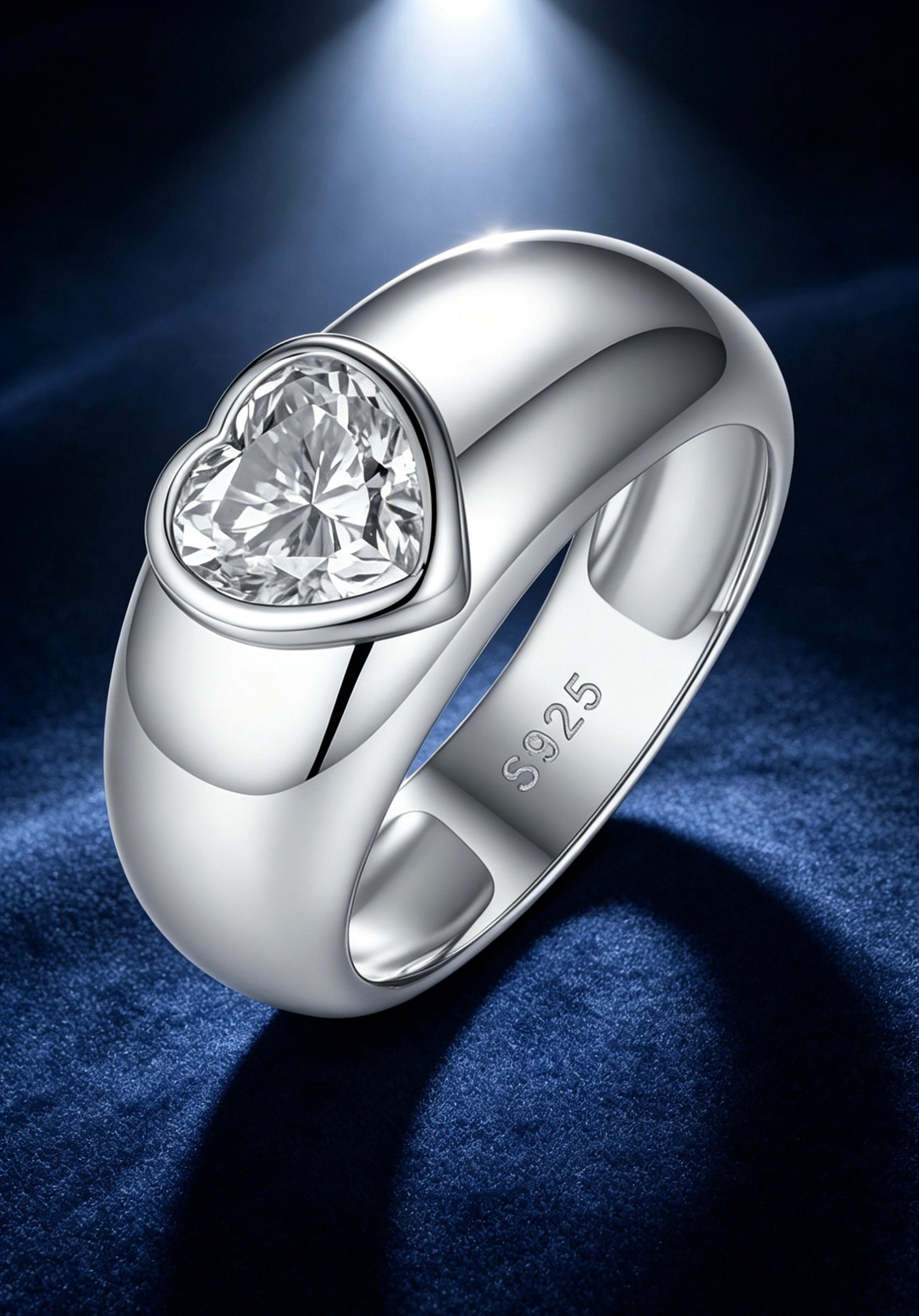 1.2ct heart-cut moissanite ring in a polished S925 silver dome band with a modern bezel setting on blue velvet.