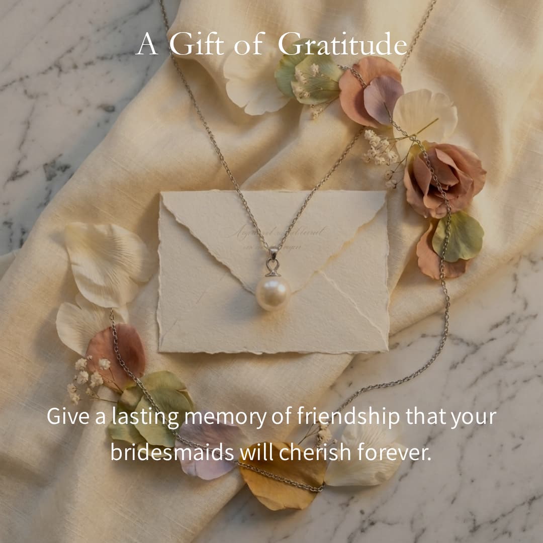 7mm Hepu saltwater pearl pendant on a silver chain resting on a cream envelope and fabric with floral accents.