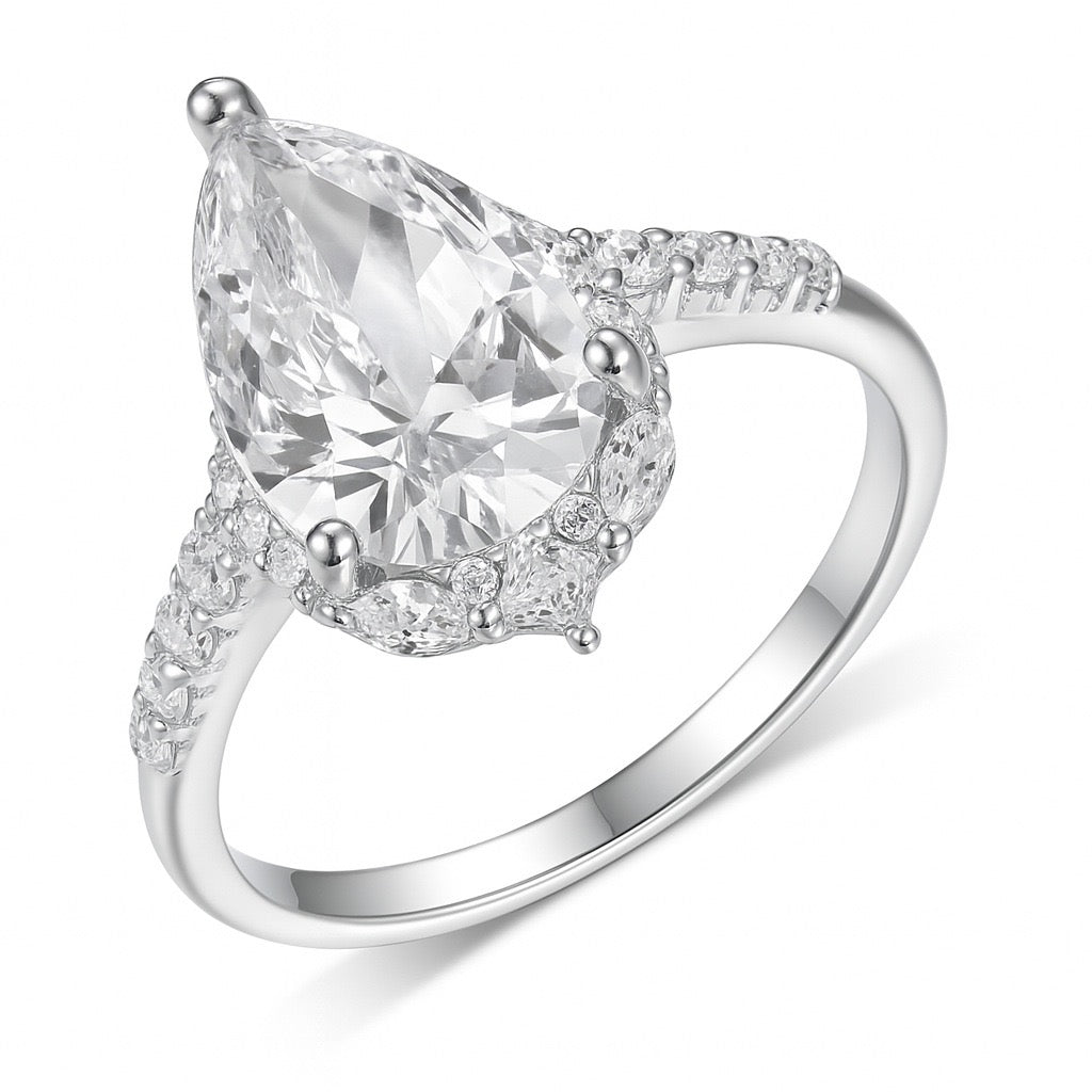 8x12mm pear-cut moissanite halo ring in S925 silver with marquise and pavé accents on a polished band.