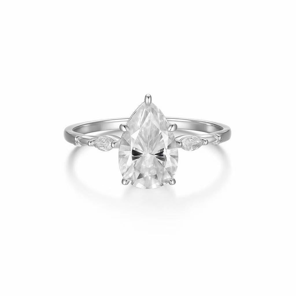 Pear-cut moissanite engagement ring in sterling silver with scattered marquise and round petal-style accent stones.