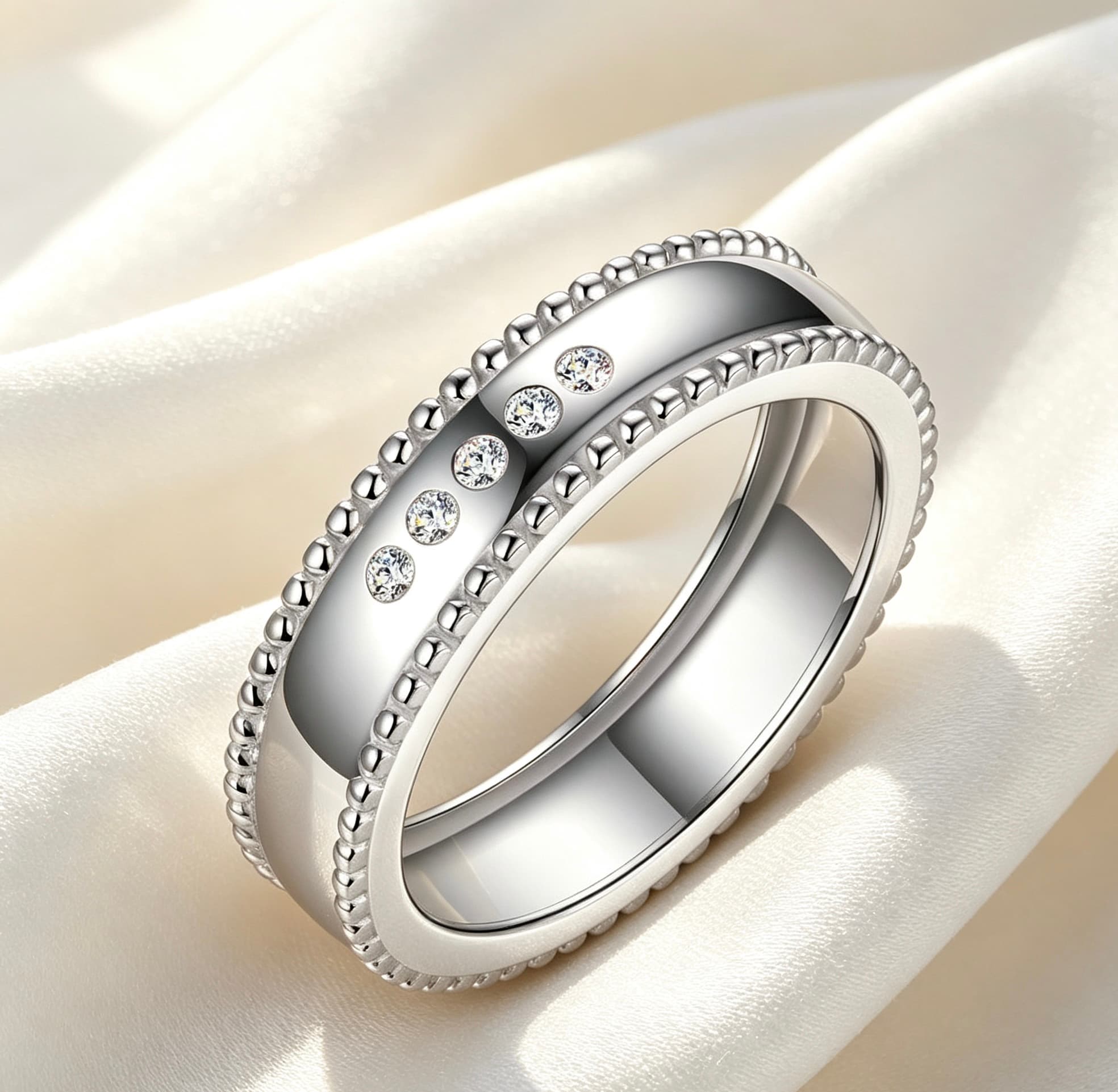 Wide sterling silver men's wedding band with beaded edges and five sparkling moissanite stones on a white silk background.