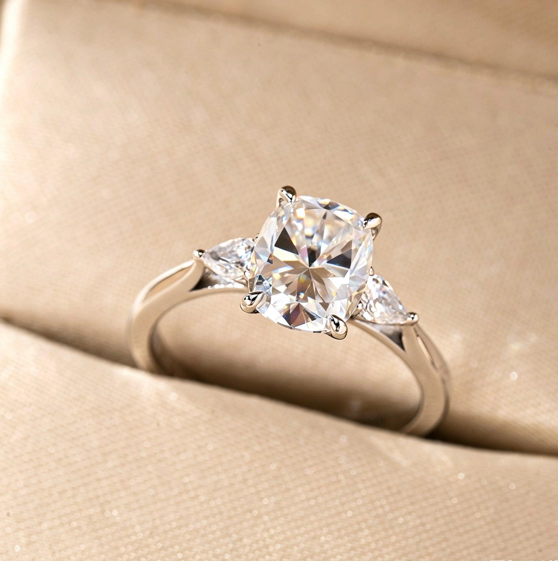 7x9mm cushion cut moissanite three-stone ring with pear side stones in a vintage S925 silver setting.