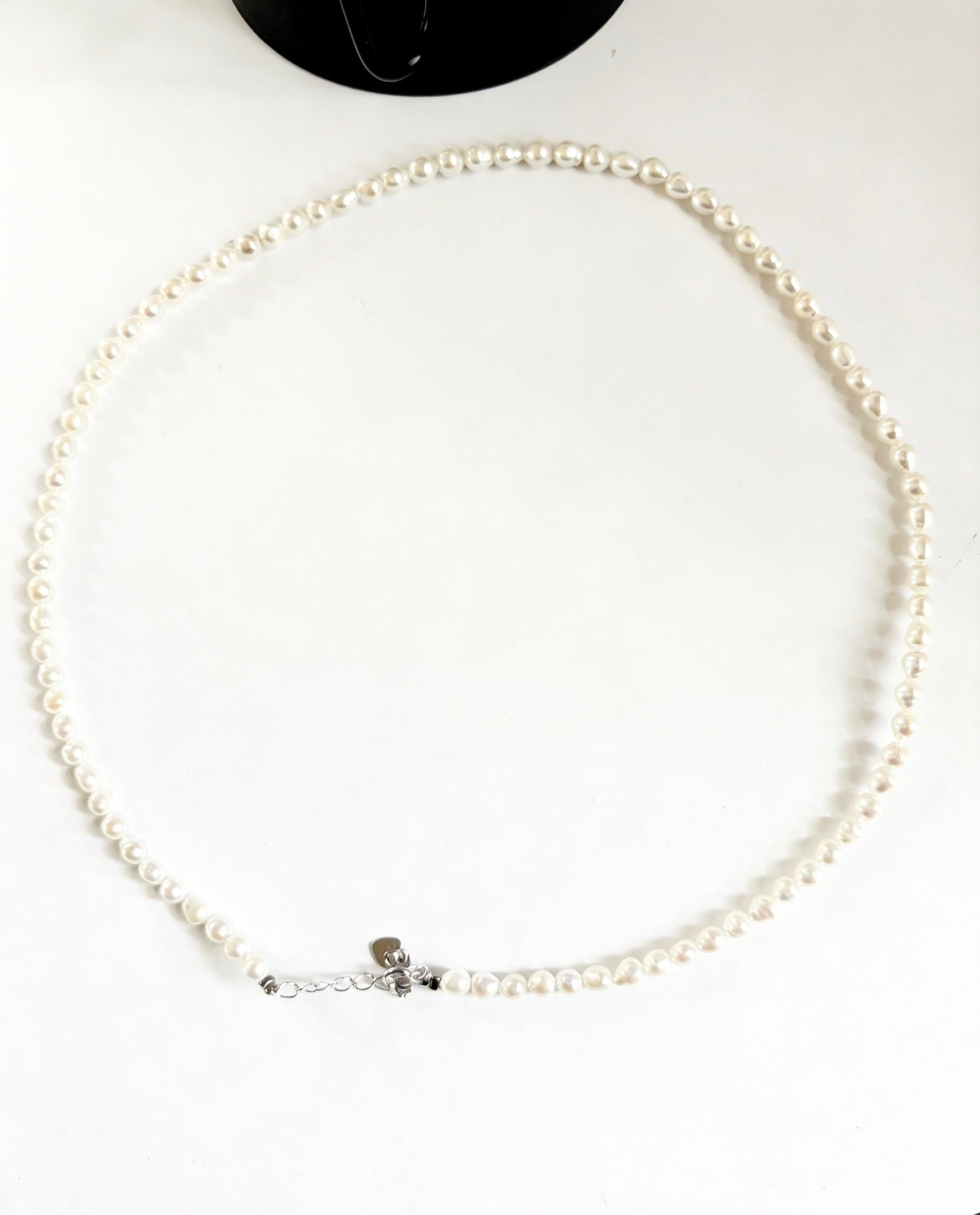Minimalist 3–4mm white baroque freshwater pearl seed necklace with a 925 sterling silver clasp on a white background.