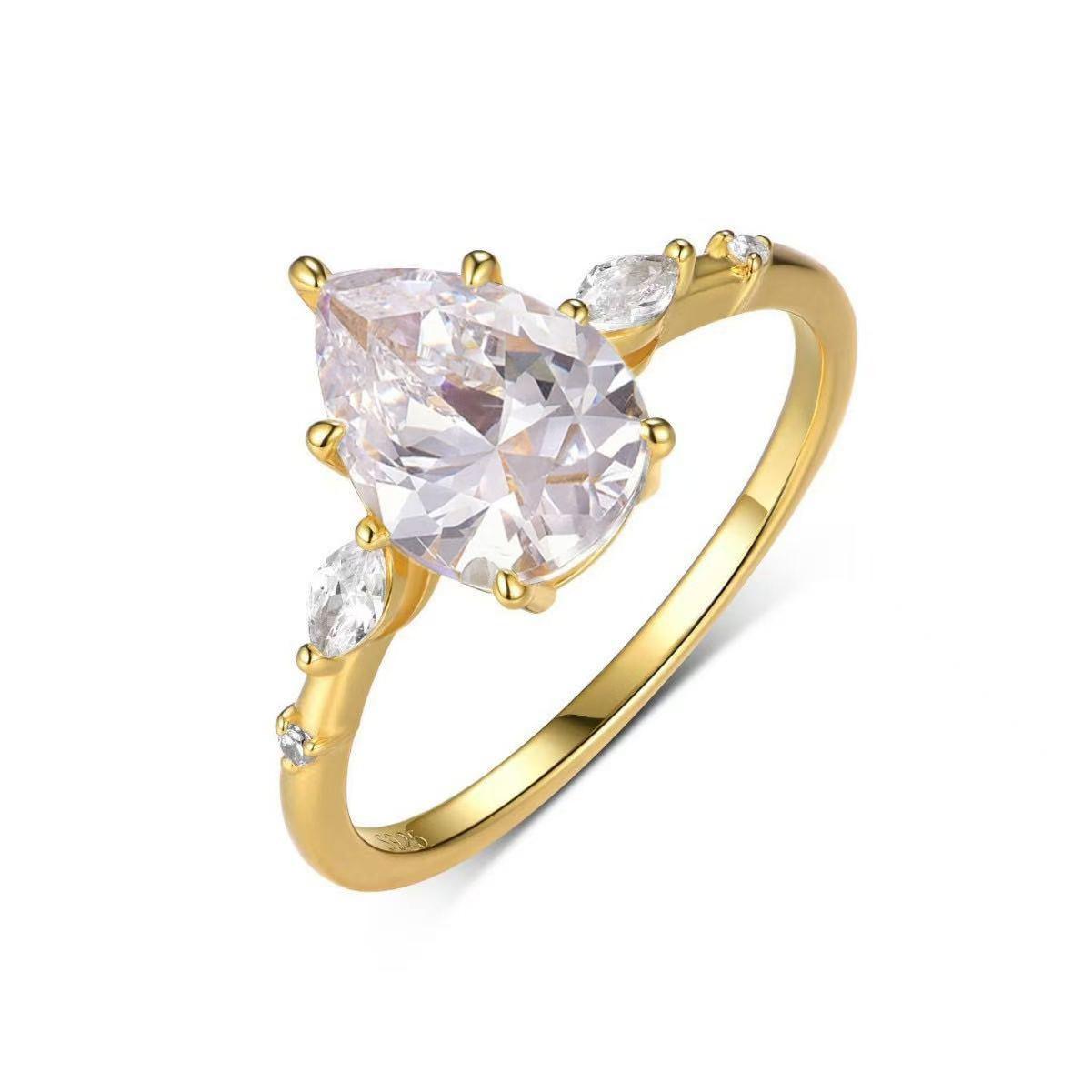 Gold pear-cut moissanite engagement ring with scattered marquise and round stone accents on a delicate S925 silver band.