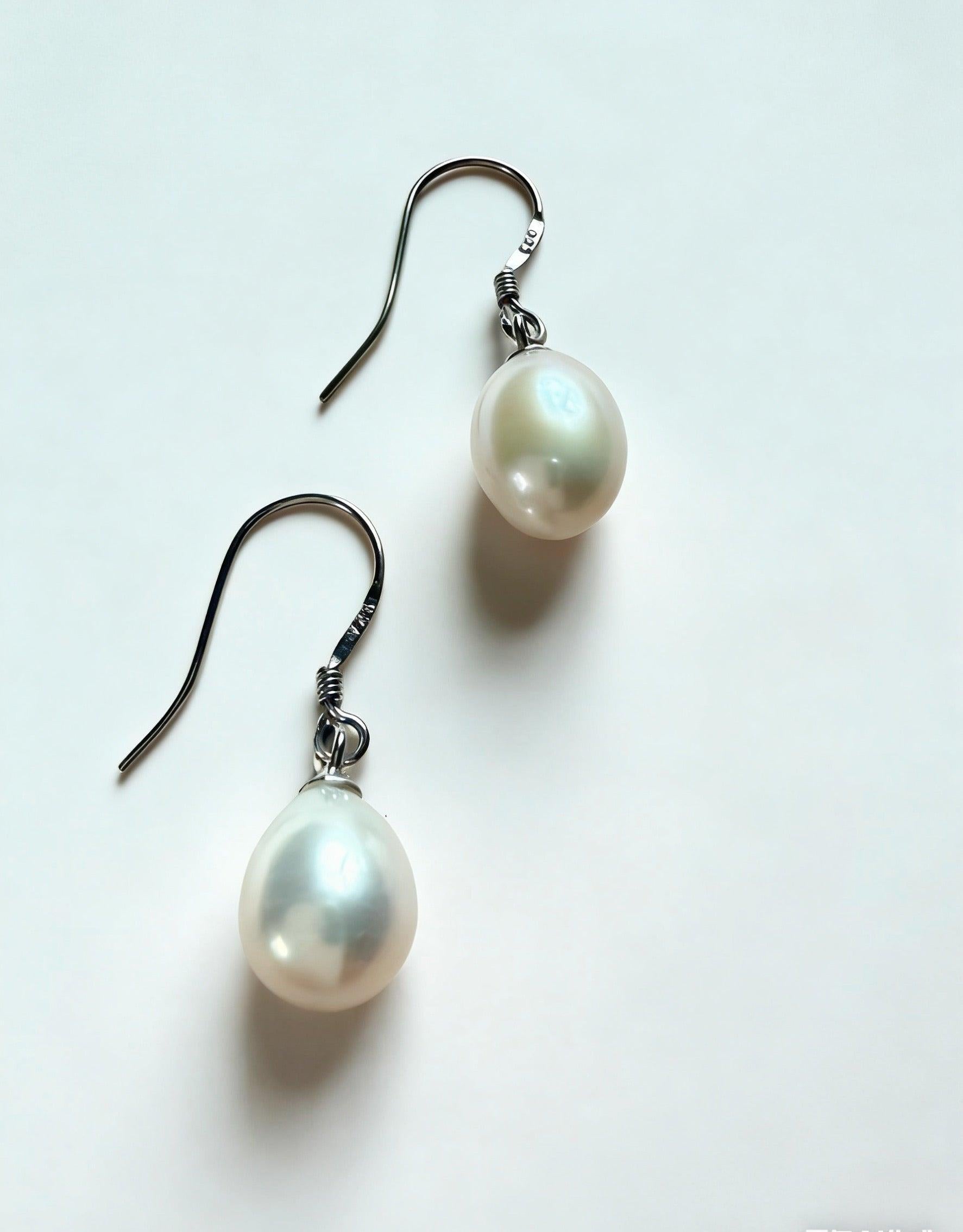 Baroque freshwater pearl drop earrings with 7-8mm white pearls on 925 sterling silver hooks.