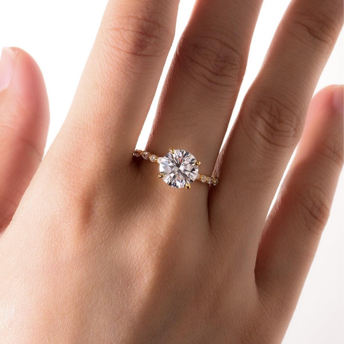 9mm round moissanite ring in gold-plated S925 silver with marquise-cut accent stones on a delicate band.