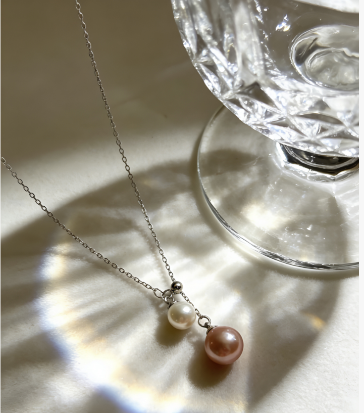 Double freshwater pearl pendant necklace with 6-7mm peach pink and 4-5mm white pearls on a 925 sterling silver chain.